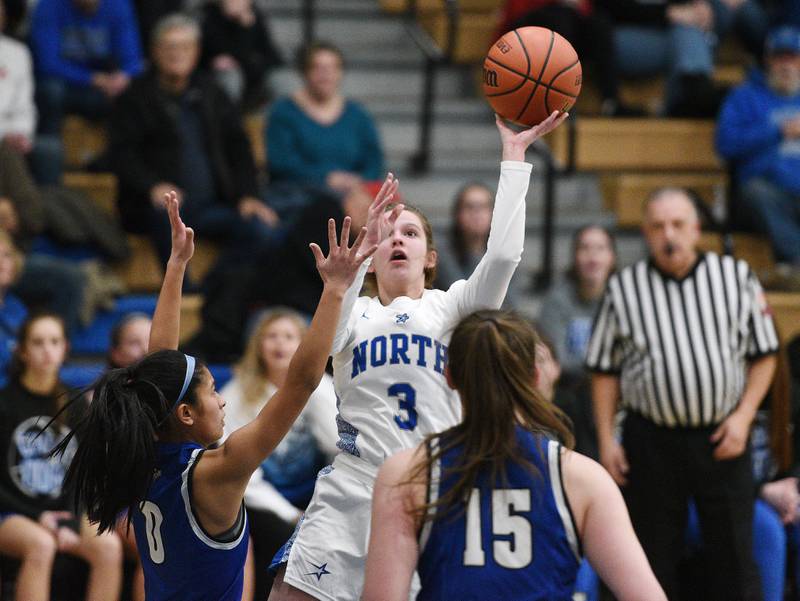 St. Charles North's Alyssa Hughes (3) takes a shot around the Geneva defense during Thursday’s girls basketball game in St. Charles.