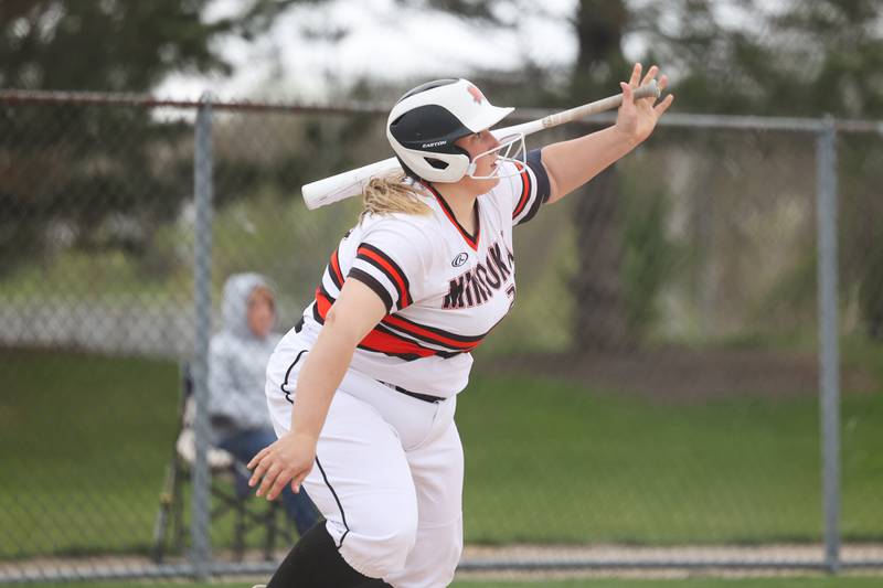 Minooka’s Madison Kelly watches the ball clear the fence for a solo home run against Oswego on Wednesday, April 17, 2024 in Minooka.