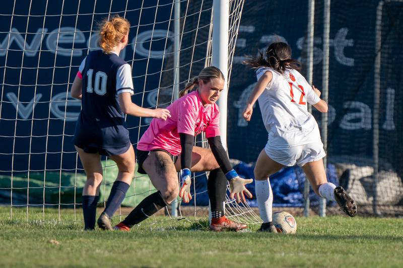 Oswego East's Samantha McPhee (0) defends the net against Oswego’s Dahlia Fuentes (12) during a soccer match at Oswego East High School on Thursday, Apr 6, 2023.