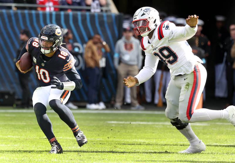 Chicago Bears quarterback Caleb Williams scrambles away from New England Patriots defensive end Keion White during their game Sunday, Nov. 10, 2024, at Soldier Field in Chicago.