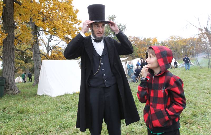 President Abraham Lincoln (Kevin J. Wood) fixes his hat while talking with Gavin Siltman, 10, of Lake Villa during Hainesville’s Civil War Encampment & Battle at the Northbrook Sports Club on October 21st in Hainesville. 
Photo by Candace H. Johnson for Shaw Local News Network