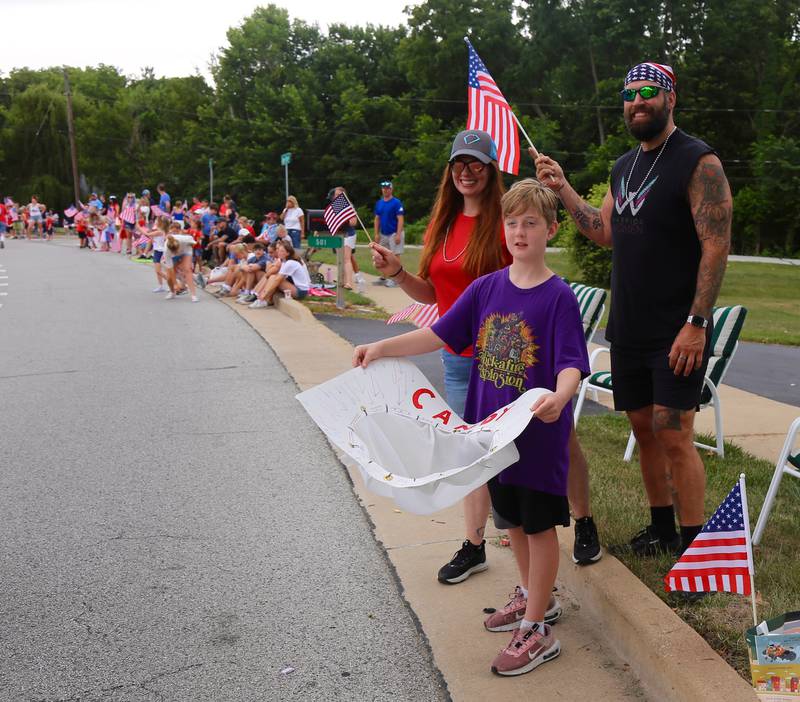 Ten year old Connor Kelly holds out his candy catcher while Stephanie Kelly and Jason Henry look on during the Yorkville Independence Day Parade on Friday, July 4, 2025.