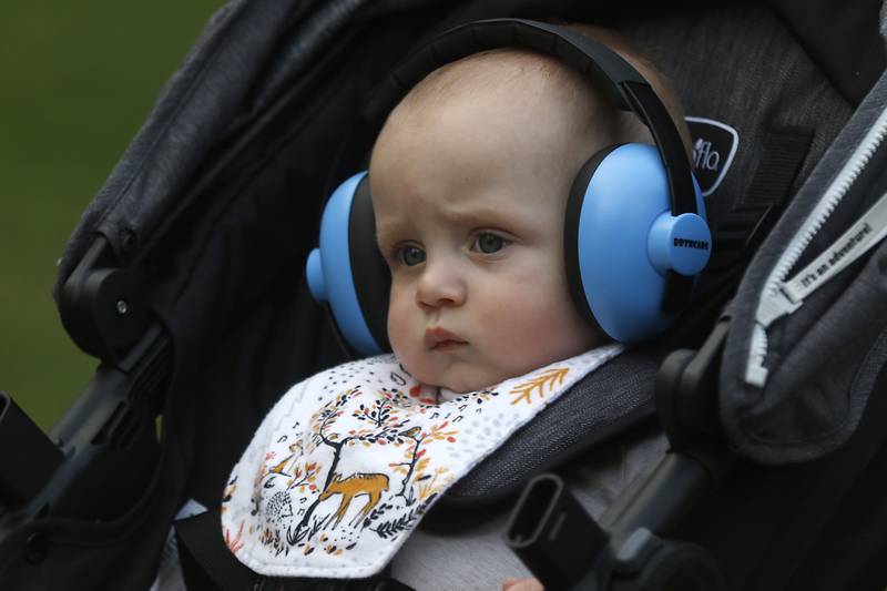 Emerson Bartlett, 8 months, sports headphones as hie listens to his mother, Clarissa Bartlett, play during a performance of the Woodstock City Band on Wednesday, July 24, 2024, in the historic Woodstock Square. The band that is in its 140th season, performed their Galloping through the Gallery concert for the crowd.