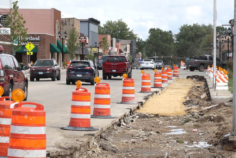 Cars pass by the sidewalk construction Wednesday, Aug. 28, 2024, on Main Street in Genoa.