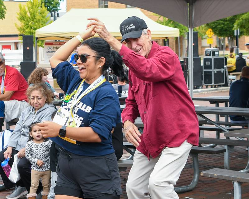 Bea Mishler, left, gets spun around while dancing with George Poe, a close friend’s father, during the Taste of DeKalb on Sunday, Sept. 29, 2024, after Bea and her friends ran in the DeKalb Corn Classic earlier in the day.