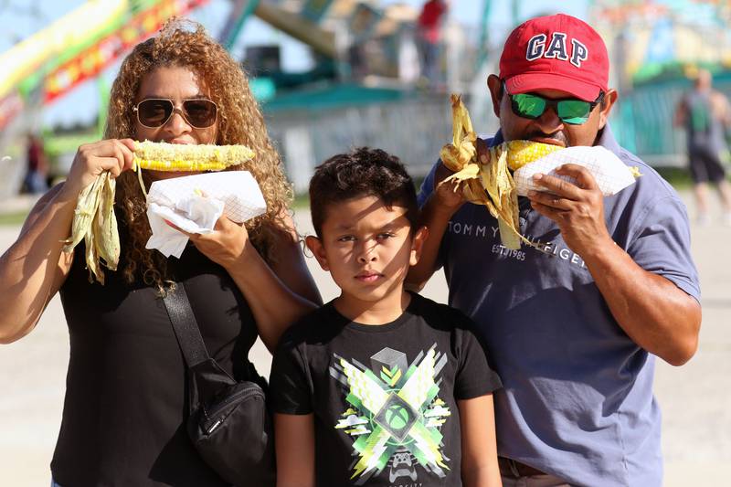 Eloisa and Wilmer Garcia, of Beach Park and their son, Joey, 9, enjoy eating some fresh roasted corn on the cob during the Lake County Fair at the Lake County Fairgrounds on Sunday, July 30th in Grayslake.  
Photo by Candace H. Johnson for Shaw Local News Network
