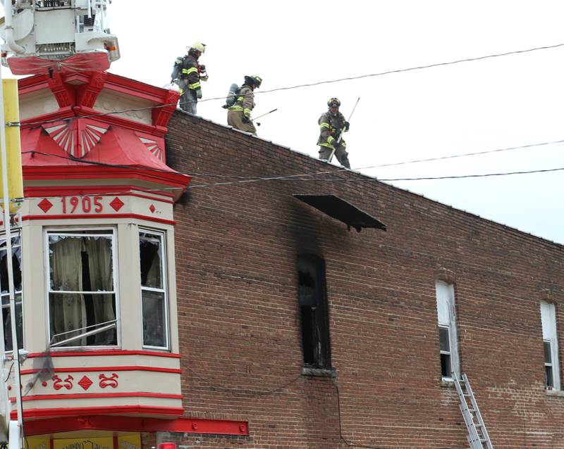 Firefighters remove debris off of the rooftop of a structure fire at 201 North Main Street on Monday, Aug. 14, 2023 at Ladd. The fire happened just before 7:30a.m. and was upgraded to a three-alarm fire.  Firefighters from Mendota, Ladd, Peru, La Salle, Utica, Princeton and others helped with the blaze.