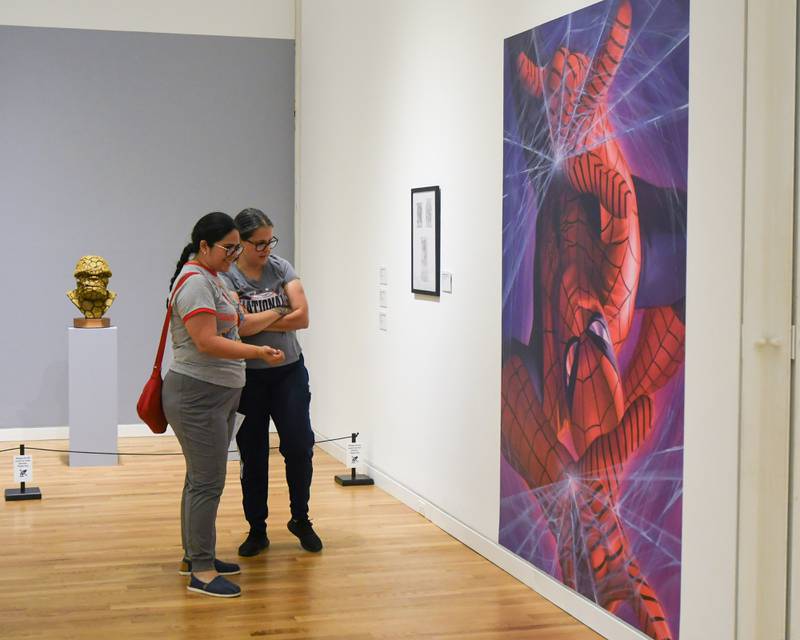 Lizzie Alarcon, left, and Veronica Fumero both from Westmont look at the artwork of Alex Ross during the Marvelcity: The Art of Alex Ross exhibit held at the Elmhurst Museum on Saturday June 24, 2023.