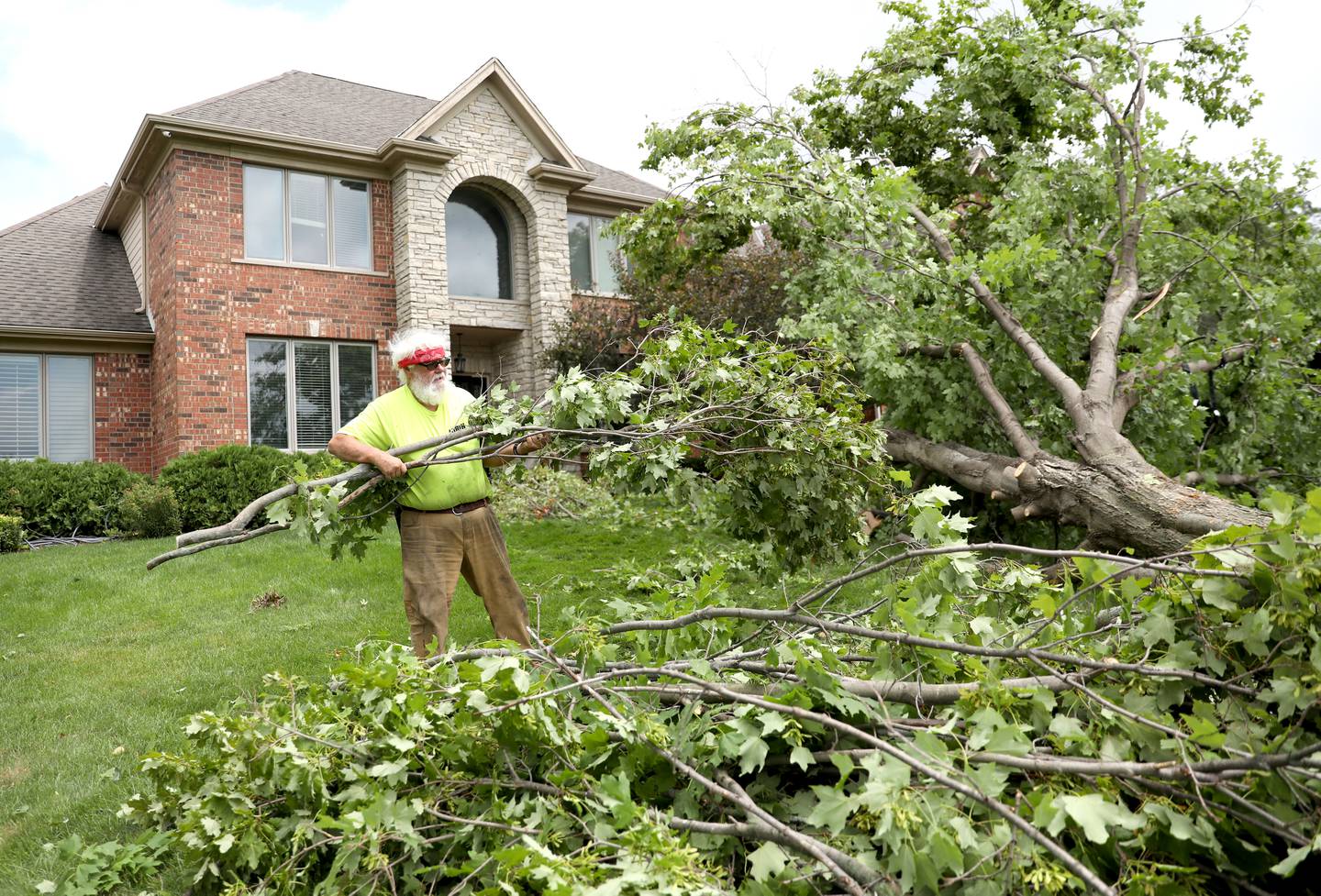 Lorin Womack of Lorin’s Tree Stump Removal in Leland helps remove downed trees in unincorporated Elgin on Thursday, July 13, 2023. A tornado touched down in a neighborhood near Corron and Bowes roads on Wednesday, July 12, 2023.