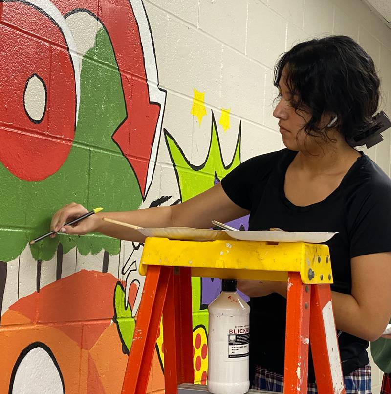 La Salle-Peru High School art students work on creating a mural for a blank wall at the Peru YMCA.