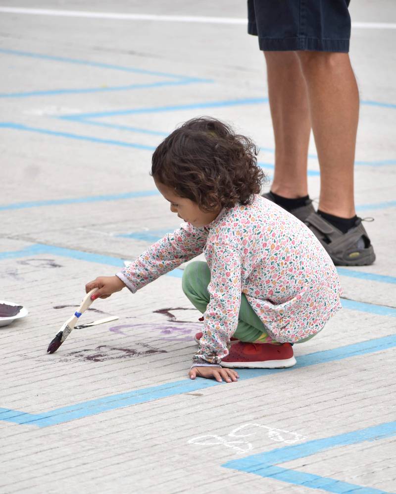 A young artist paints her square on Main Street in Morrison on Saturday. The Children’s Art Preservation Association holds the event as a way for the community to participate in the arts together, as families and individuals. Each registered artist was allotted a five-foot square to fill with art.