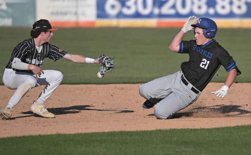 St. Charles North’s Trevor Lambel slides into second base as St. Charles East’s Jake Greenspan loses the throw in the first inning in the third game of their inter-city series at Northwestern Medicine Field in Geneva on Tuesd