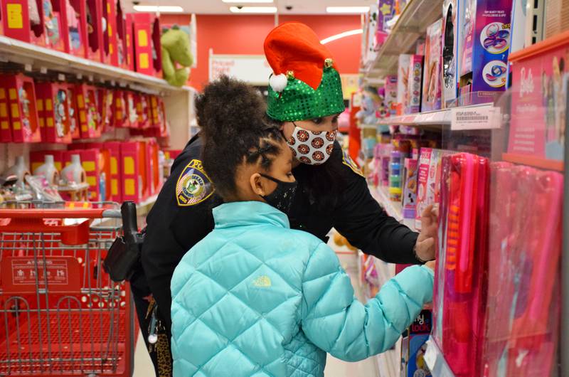 Danielle Sorenson, a school resource officer with the DeKalb Police Department, helps 8-year-old Amiyah Richardson choose a Barbie doll during the Heroes and Helpers event, held Sunday, Dec. 12, 2021 at the Target store in DeKalb.