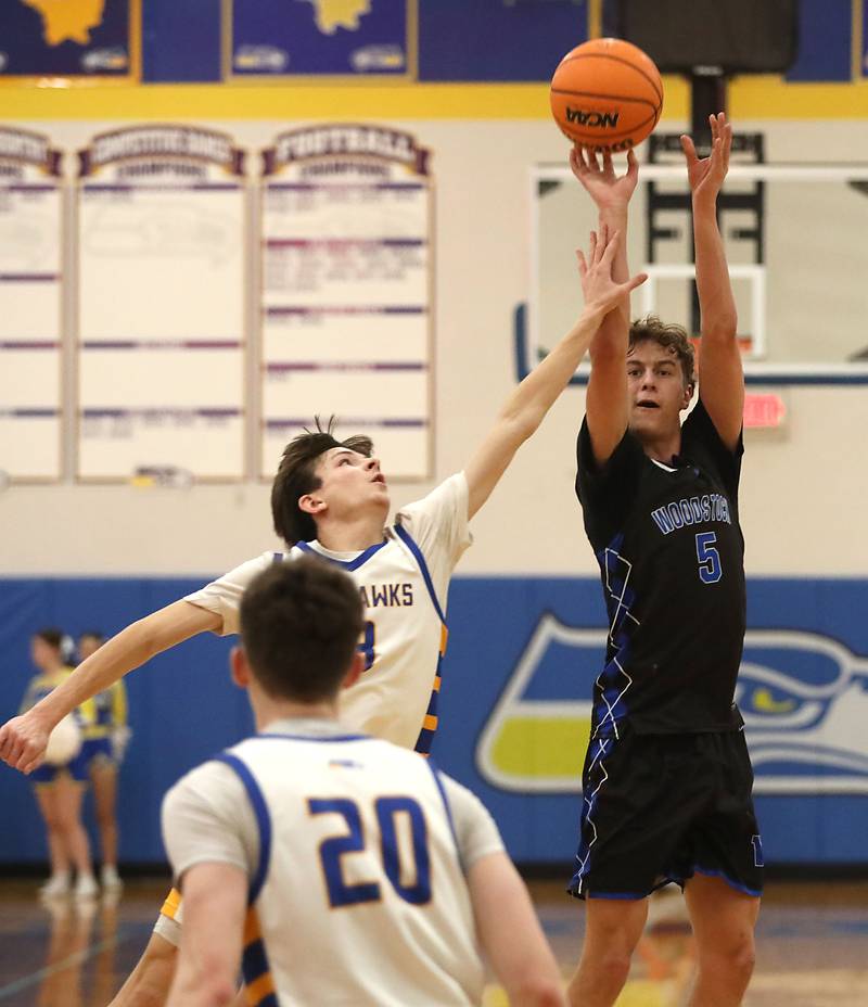 Woodstock's Max Beard shoots the ball over Johnsburg's Trey Toussaint during a Kishwaukee River Conference boys basketball game on Friday, February. 13, 2026, at Johnsburg High School.