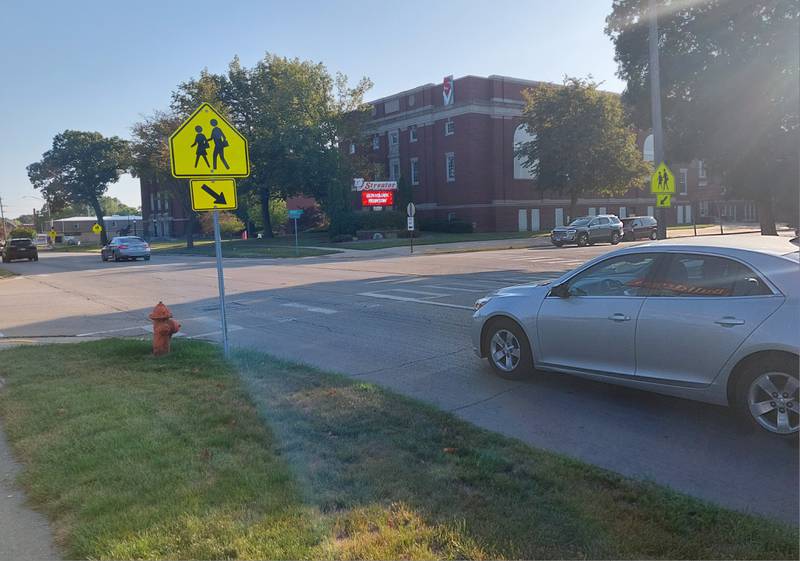 Signs warn motorists driving by Streator High School of pedestrian crossings. Some of the signs also have flashing red lights on them.