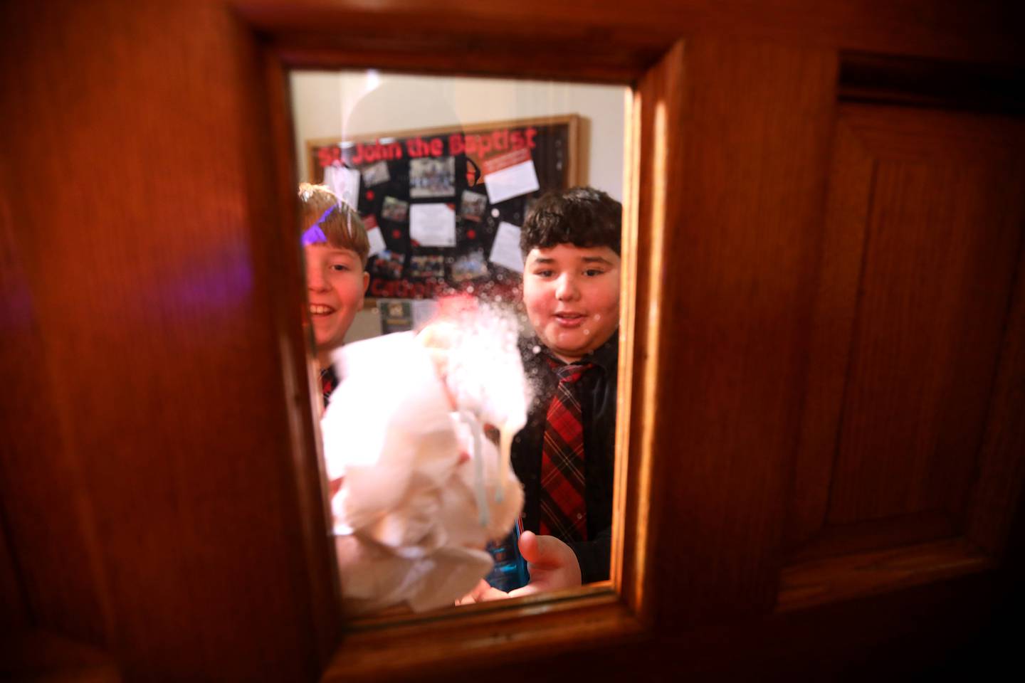 St. John the Baptist Catholic Academy middle school students Blaise Nasser and Lucas Garcia clean windows as they help clean with other classmates at St. John the Baptist Catholic Church on Thursday, Jan. 29, 2026, in Johnsburg. The students help clean parts of the church as a community service project.