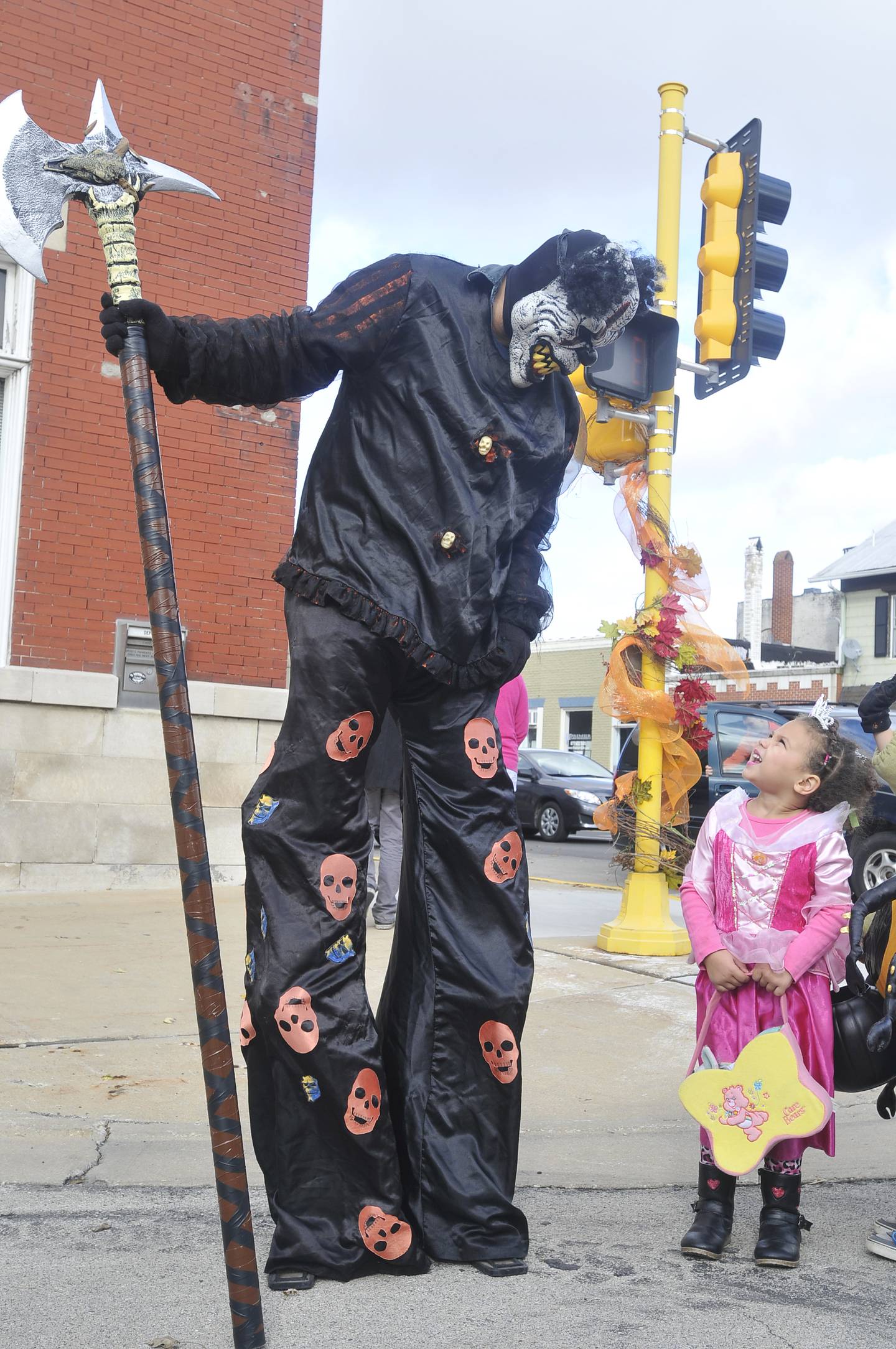 A clown character from Erickson's Monster Manor in Momence looks down to a curious 5-year-old visiting from Indiana during the 15th Annual Bordertown Hauntings downtown trick-or-treat event in 2015.