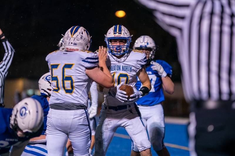 Wheaton North’s Tyler O'connor (10) is greeted in the end zone by Jackson Angelo (56) after scoring a touchdown against Geneva during a football game at Geneva High School on Friday, Oct 14, 2022.