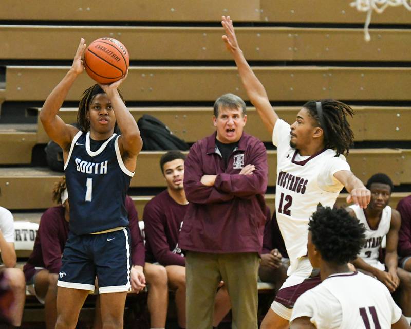 Downers Grove South's Keon Maggitt (1) takes a shot in the first quarter while being defended by Morton East's Donvan Johnson (12) during the game on Saturday Dec. 9, 2023, held at Morton high School.