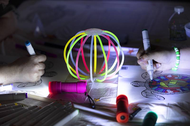 Lillyanna (left), 15, and Annalise Tranbarger 13, work on an art piece Tuesday, July 16, 2024, at the Dixon Public Library. Young adult librarian Brianna Doyle organized the glow party to bring in teens to the library. Doyle will host a program about once a quarter moving forward.