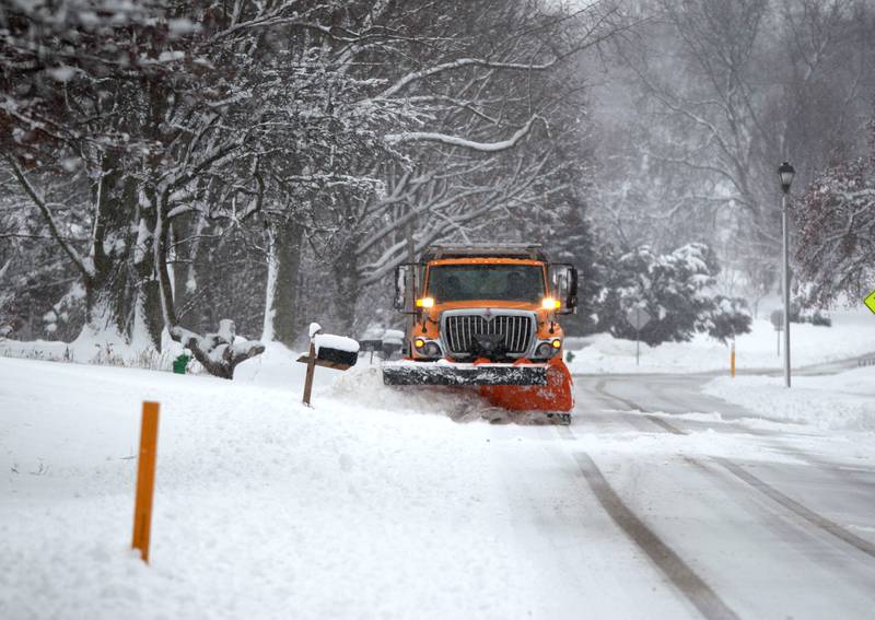 A snow plow works to clear a street in Batavia following several more inches of snowfall in Kane County on Friday, Jan. 12, 2024.