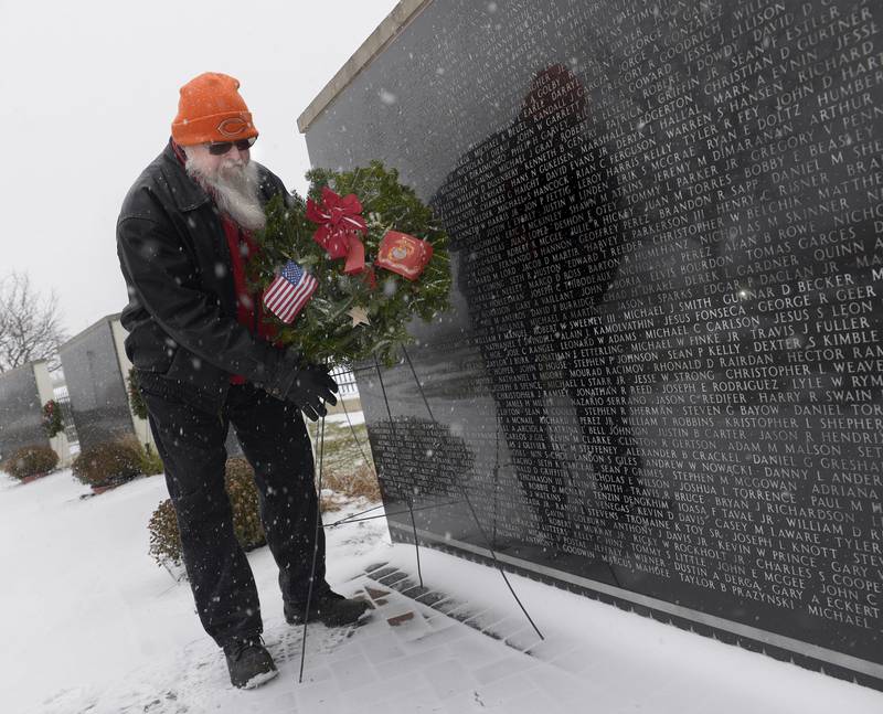 Gold Star Father Phil Clarke places a wreath at the wall bearing his son Keith’s name Saturday during the eighth annual Wreaths Across America in Marseilles.