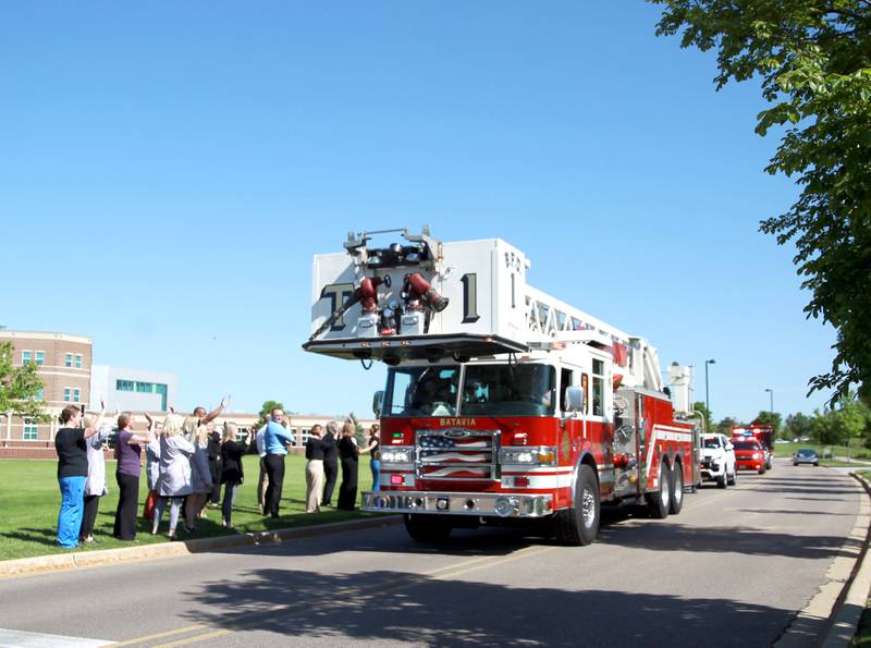 A Batavia ladder truck leads a Honorarium Brigade past Northwestern Medicine Delnor Hospital in Geneva as staff members line the hospitals ring road as part of Nurses Week on Wednesday, May 8, 2024.