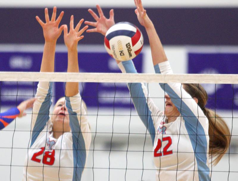 Marian Central’s Nola Midday, left, and Hadley Rogge block against Genoa-Kingston in varsity volleyball tournament action on Saturday, Sept. 21, 2024, at Hampshire High School in Hampshire.