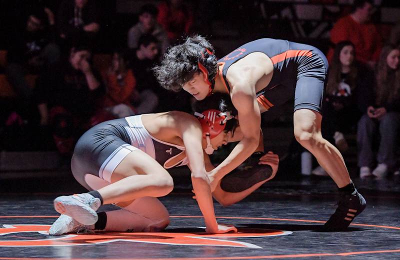 Marian Central's Andrew Alvarado and St. Charles East's Payton Lee wrestle at 132 pounds during a match in St. Charles on Wednesday, December 20, 2023.