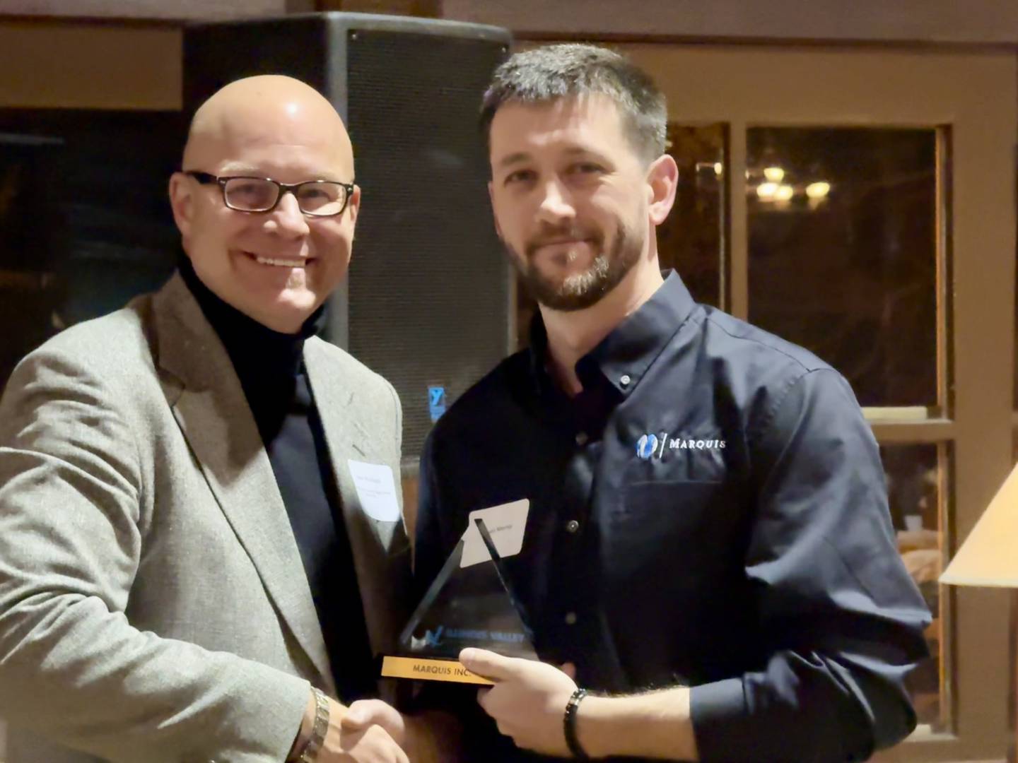IVAC President Board of Directors Dr. Steve Wrobleski shakes hands with Organizational Development Manager for Marquis Daniel Murray after Marquis is awarded the Business Builder award during IVAC's annual dinner on Thursday December 12, 2024.