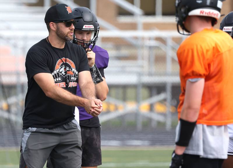 DeKalb head football coach Derek Schneeman gives some instruction Wednesday, July 15, 2025, during a summer practice session at the school.