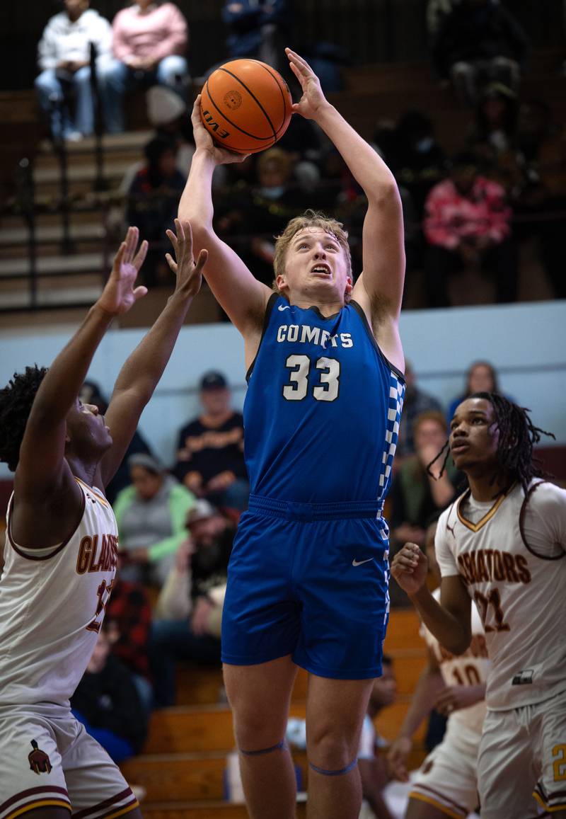 Clifton Central's Jake Thompson, center, elevates for a shot as Christ the King's Treyvon Brown-Wells, left, guards in the Kankakee Holiday Tournament at Kankakee High School on Saturday, December 27, 2025.