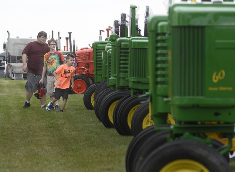 Vintage tractors of various makes and models along Burlington Street drew interest from many in between the rain showers Saturday, Aug. 20, 2022, during the Grand Ridge Community Fest.
