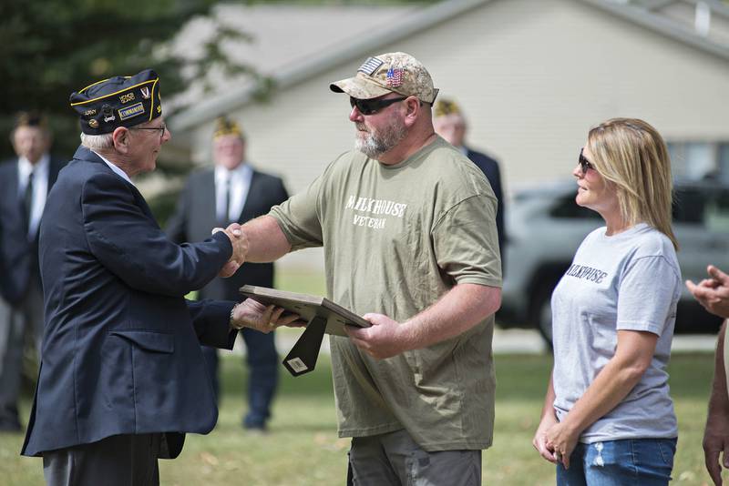 Ken Brainerd (right) accepts an award from Morrison American Legion commander Larry Zuidema for his display of flags on Crosby Road in Morrison.