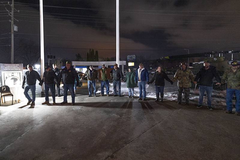 After the names are read, the group joins hands to the playing of “I’ll Be Home for Christmas,” Saturday, Dec. 6, 2025.