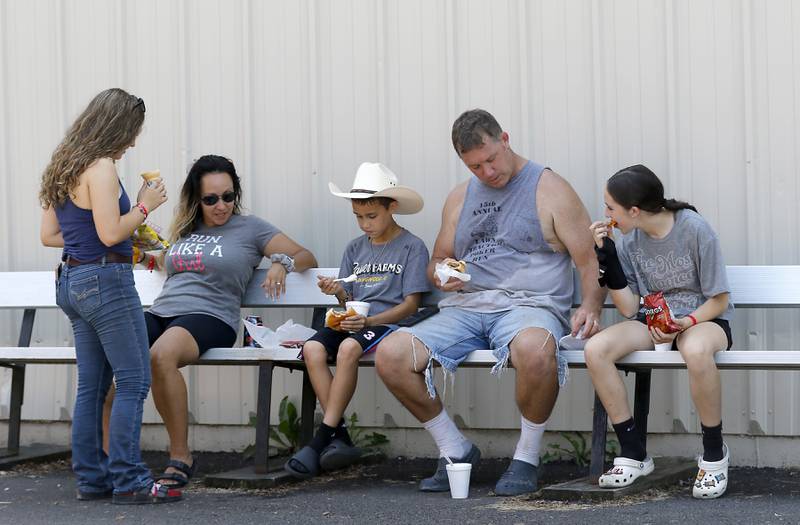 The Bauer family from Ringwood, (from left to right) Ava, Elisa, Luke, Steve, and Grace, eat lunch together during the opening day of the McHenry County Fair on Tuesday, July 29, 2025. The fair runs through Sunday at the fairgrounds in Woodstock.