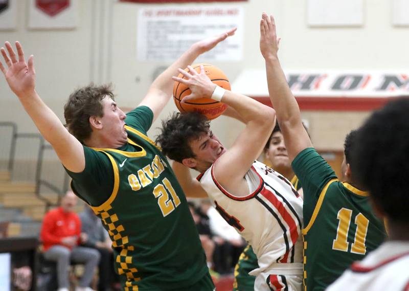 Huntley's Casey Kaczmarski (center) tries to get out of the pressure by Crystal Lake South's Ryan Morgan (left) and Michael Santos (right) during a Fox Valley Conference boys basketball game on Wednesday, Dec. 10, 2025, at Huntley High School.
