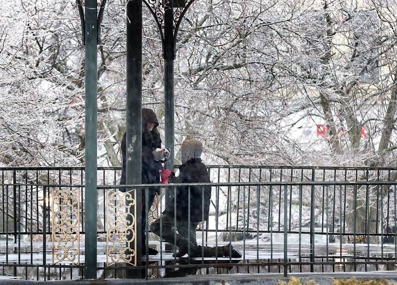 Jonathan Gettig of Woodstock proposes to Lizzette Gettig of Chicago in the gazebo in the historic Woodstock Square on Wednesday, Feb. 22, 2023, as a winter storm that produced rain, sleet, freezing rain, and ice moved through McHenry County.