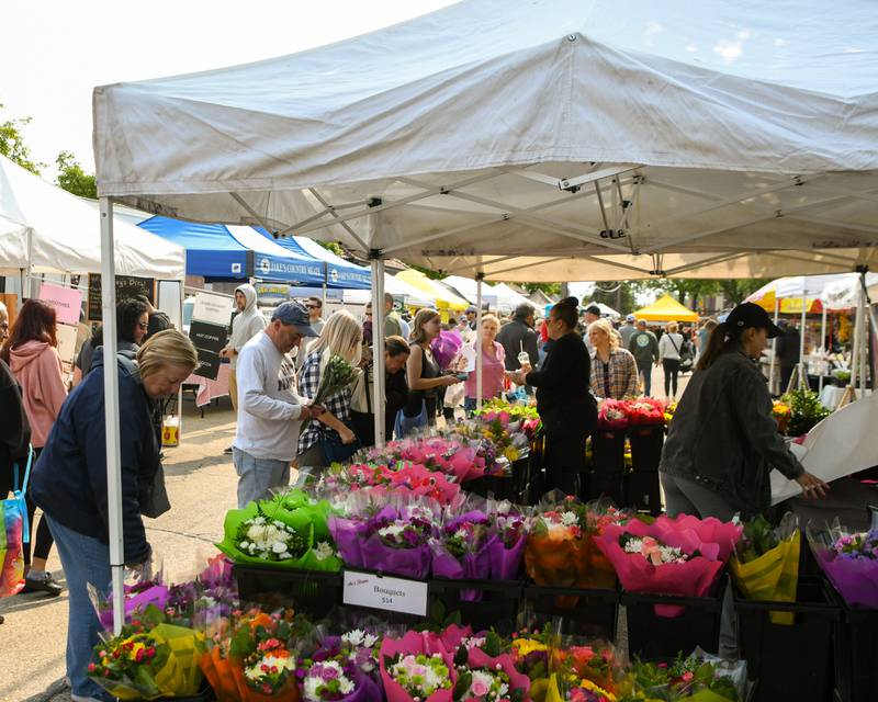 Community members stop and pick out flowers on Saturday May 31, 2025, during the Farmers Market on Saturday May 31, 2025, held at the Main Street train station parking lot in Downtown Downers Grove.
