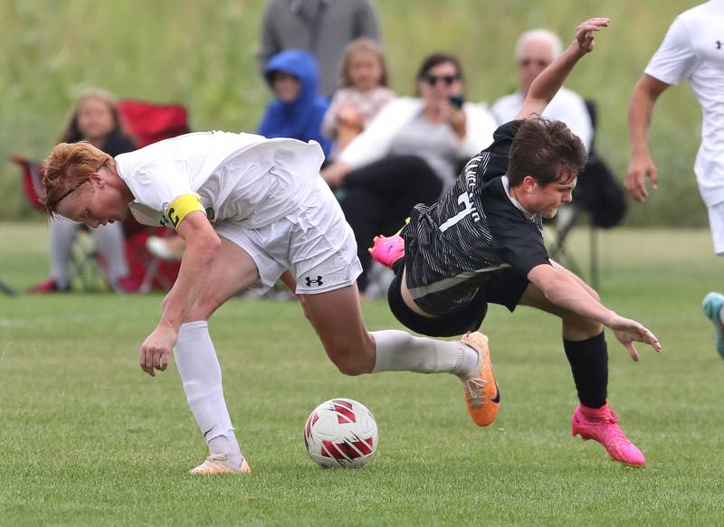 Kaneland's Cameron Guernon is tripped up after trying to steal the ball from Sycamore's Jameson Carl during their game Wednesday, Sept. 6, 2023, at Kaneland High School in Maple Park.