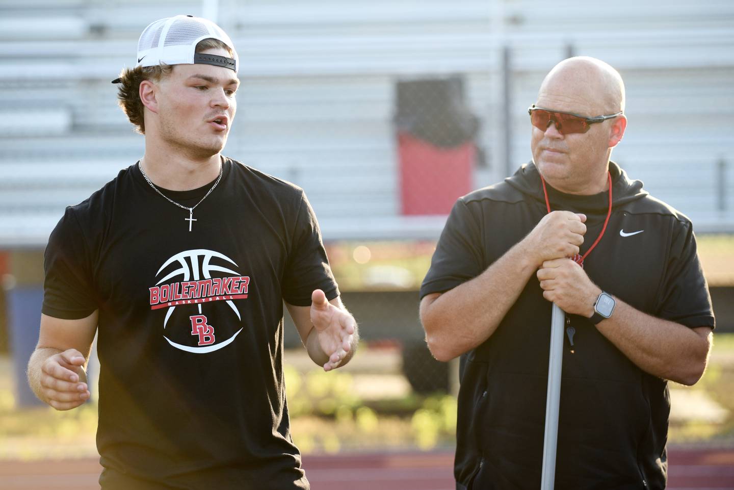 Ethan Kohl, left, a 2024 Bradley-Bourbonnais graduate, speaks to campers at the Bradley-Bourbonnais quarterback camp run by Kohl and his father, Bradley-Bourbonnais head coach Mike Kohl, right, at Bradley-Bourbonnais Wednesday, July 2, 2025.