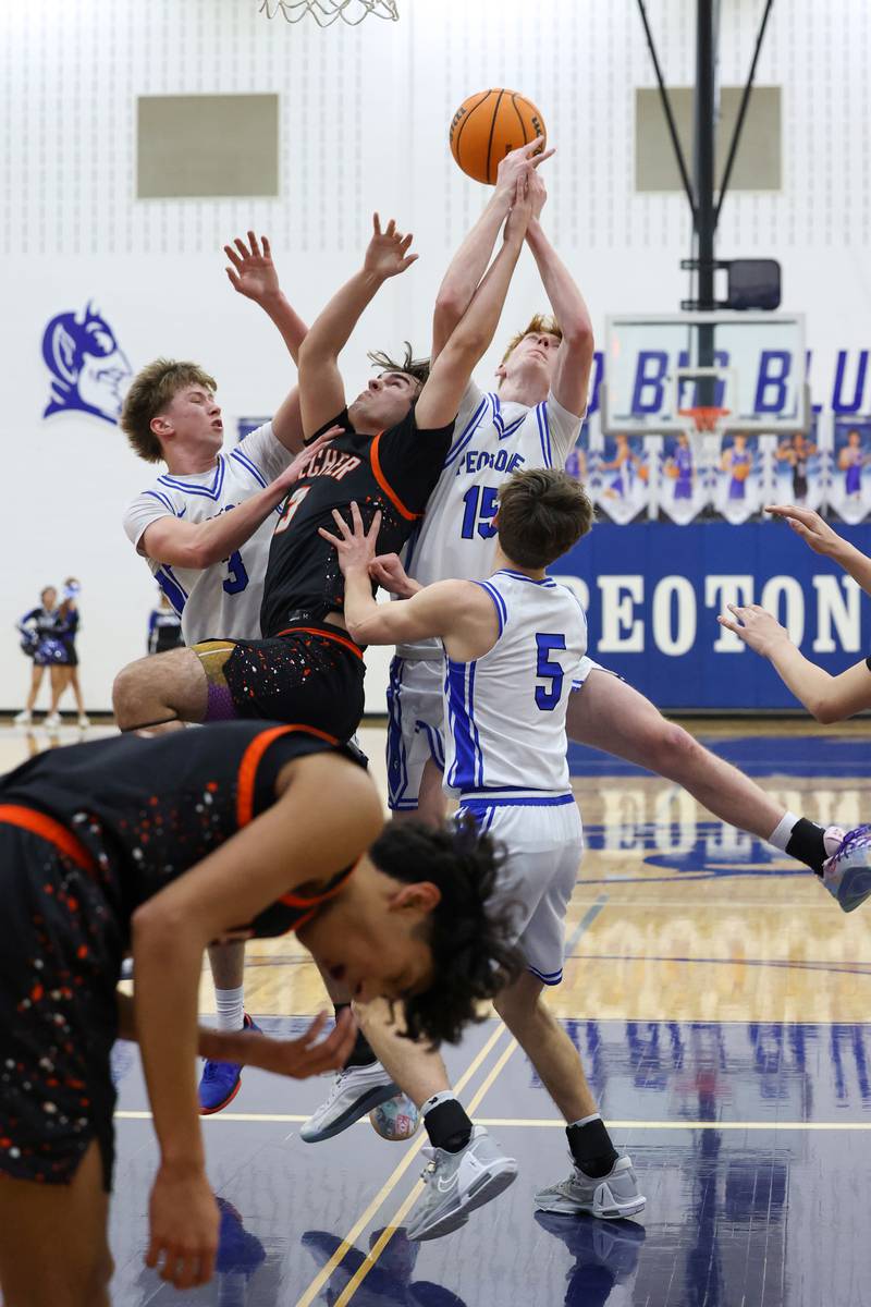 Beecher's Kyle Kasput, center, reaches for a rebound against Peotone players during the Blue Devils' 64-52 victory over Beecher on Wednesday, Jan. 28, 2026.