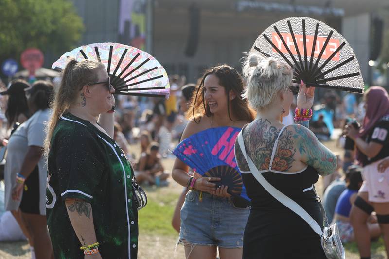 Taya Kroeger, left of Bensenville, Jessica Rodriguez and Alissa Potts, both from Chicago use fans to beat the heat while listening to the music at Lollapalooza on Sunday, Aug. 4, 2024 in Chicago.