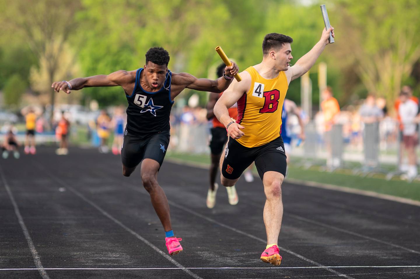 St. Charles North’s Ayodele Bateye (left) beats Batavia’s Ryan Whitwell in the anchor leg of the 4x100 meter relay race during a DuKane Conference boys track and field meet at Geneva High School on Thursday, May 11, 2023.