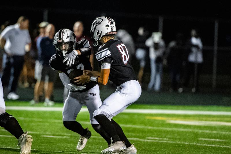 Plaifield Norths Jonnie Laurenti hands off the ball to Devan Skuja during a game against Oswego East on Friday Sept. 12, 2025 at Plainfield North High School in Plainfield