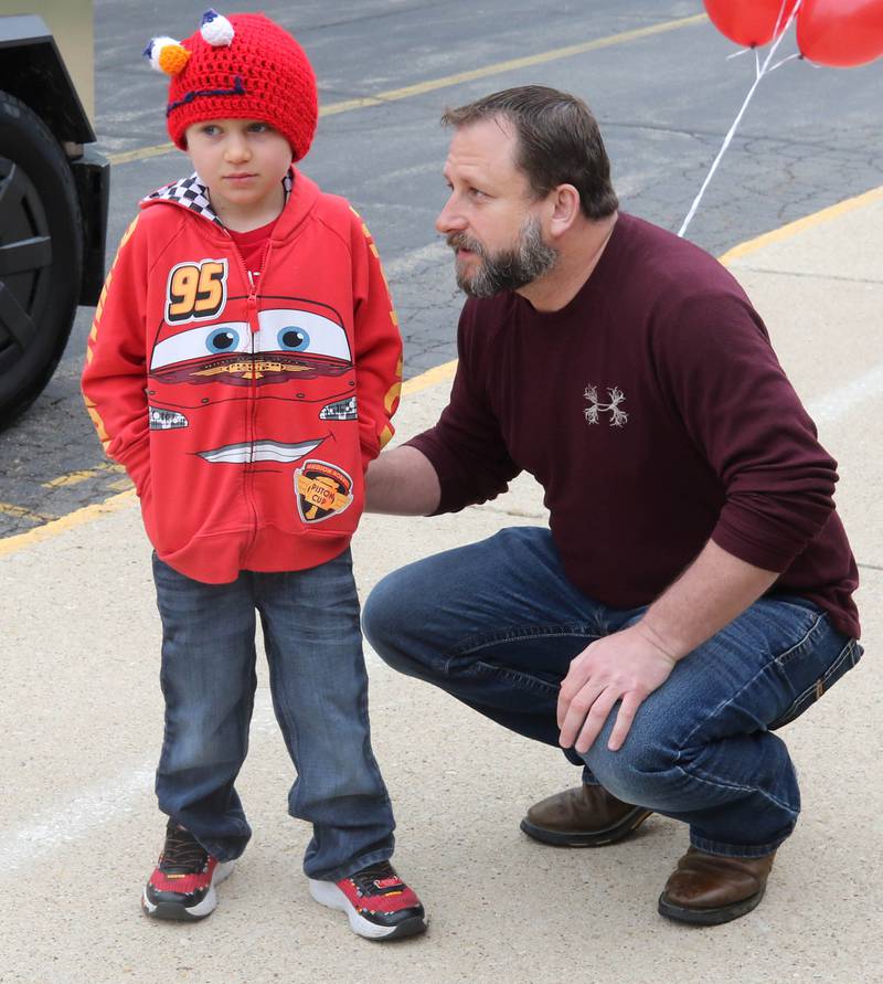 Marshall Morong, 7, a first grader at Hinckley-Big Rock Elementary School, talks to his dad John Monday, May 5, 2025, as he arrives for his first day back at school after missing months waiting for, and eventually receiving, a heart transplant. Morong arrived in style in a Tesla Cybertruck donated for use by Telsa of Naperville, along with an escort by Hinckley and Big Rock first responders.
