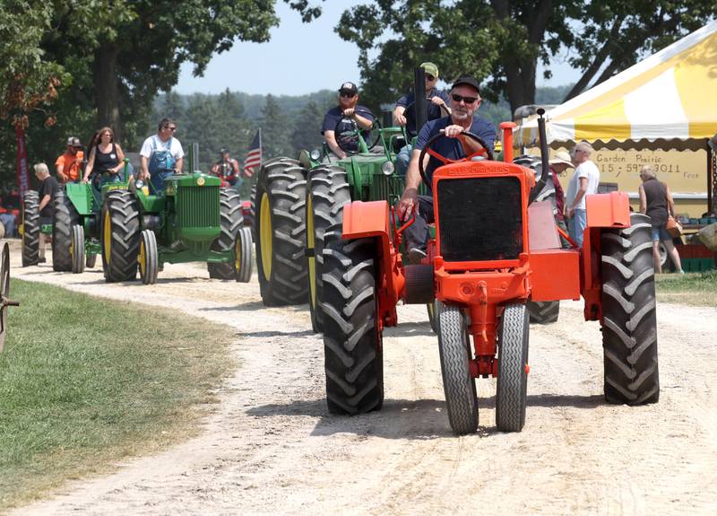 Antique tractors make their way through the parade route Thursday, Aug. 8, 2024, during the 67th annual Sycamore Steam Show and Threshing Bee at Taylor Marshall Farm.