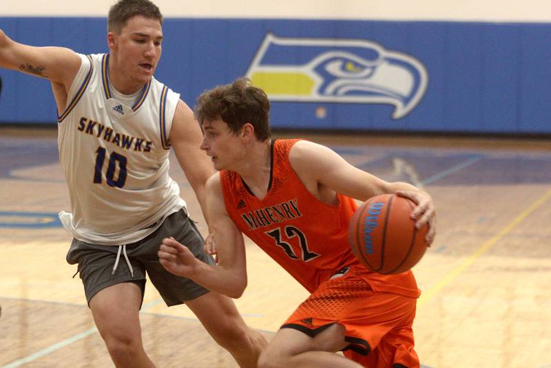 McHenry’s Anthony Fowler, right, drives on Johnsburg’s Mason Sobiesk during an alumni basketball game at Johnsburg High School Saturday evening to benefit the family of Jackson Werderitch, a 10-year-old who was struck by a car.