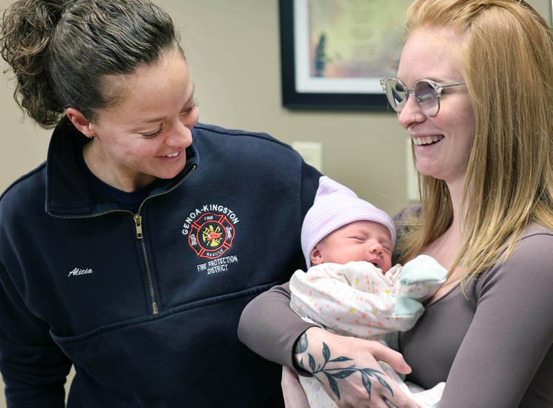 Genoa-Kingston firefighter paramedic Alicia Dimova smiles at a napping Eleanor Lee Altepeter-Knotts, and her mom Sammie Altepeter from Kingston Thursday, Nov. 2, 2023, as the baby and her family visit the Genoa-Kingston Fire Department in Genoa. Dimova and the rest of the ambulance crew delivered the baby in the ambulance along the side of the road Sept. 29 when they realized they weren’t going to make it to the hospital in time.
