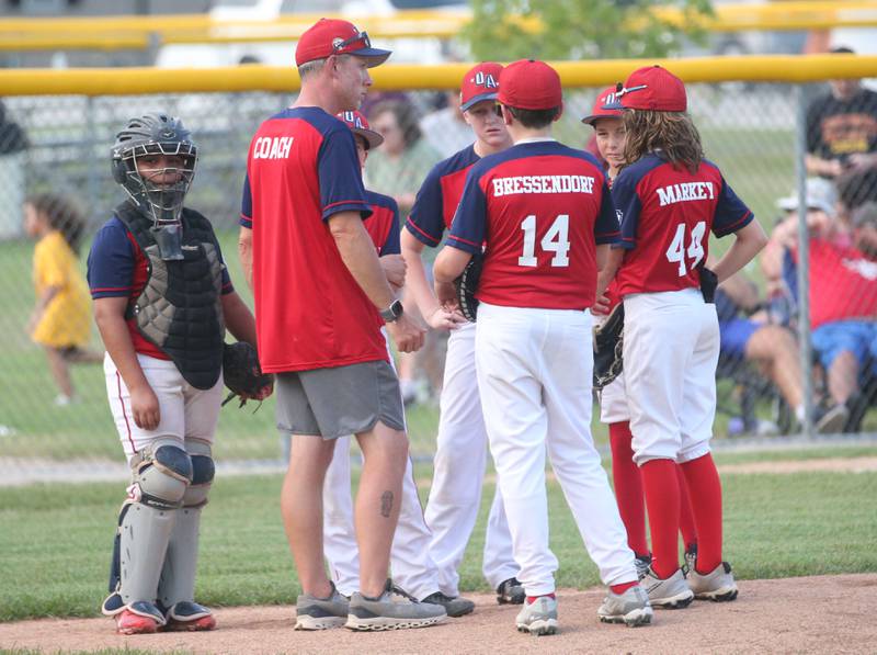 Members of the Ottawa American baseball team huddle on the mound while playing Streator All Stars during the District 20 championship game on Sunday, July 14, 2024 at Washington Park in Peru.